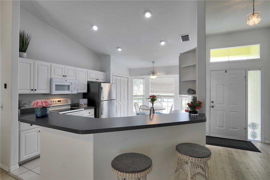406 Perch Lane Sebastian, FL 32958 - Photo 8 of 27 a kitchen with stainless steel appliances granite countertop a sink refrigerator and cabinets