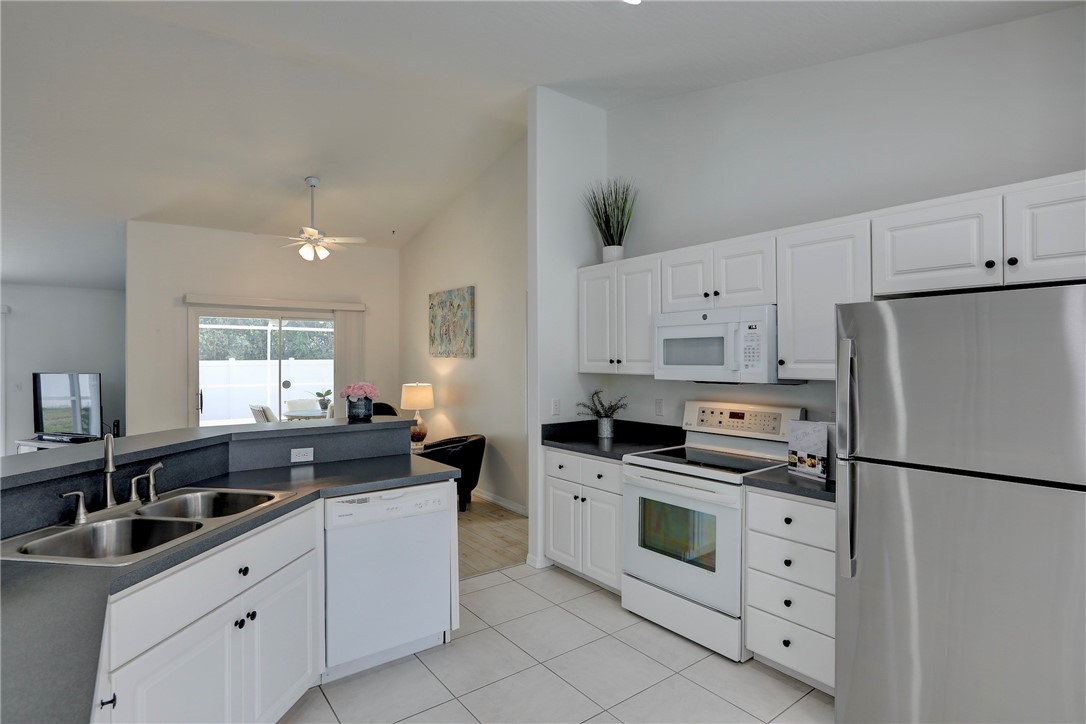 406 Perch Lane Sebastian, FL 32958 - Photo 9 of 27 a kitchen with white cabinets and white appliances