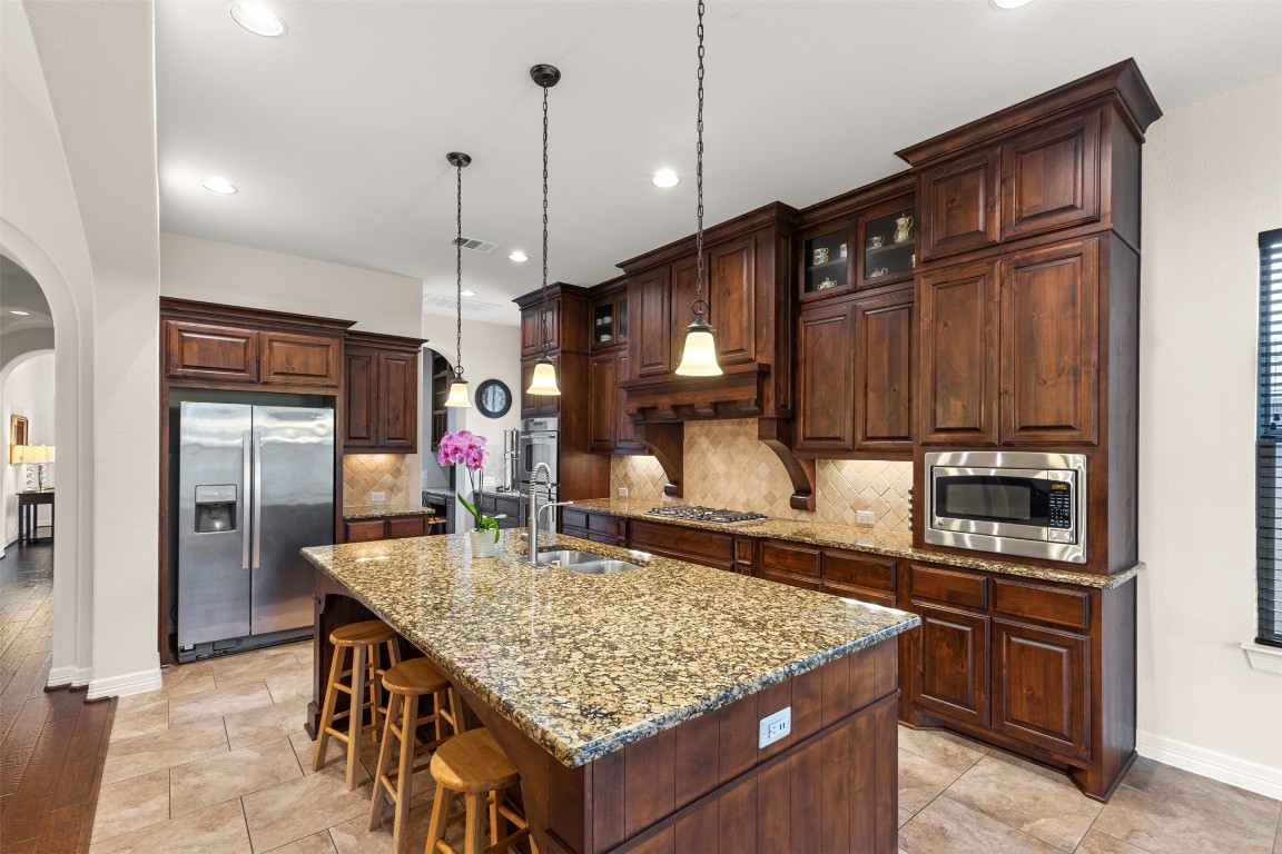 1916 Buffalo Speedway Leander, TX 78641 - Photo 14 of 30 a kitchen with stainless steel appliances granite countertop a kitchen island a cabinets and wooden floor