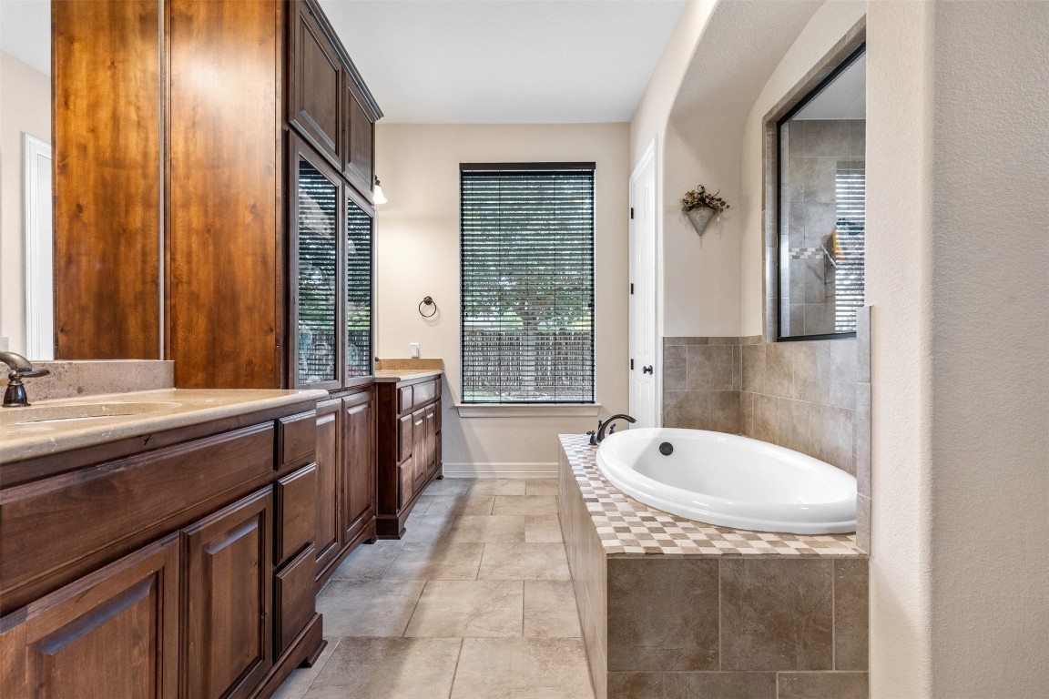 1916 Buffalo Speedway Leander, TX 78641 - Photo 18 of 30 a spacious bathroom with a tub sink and mirror