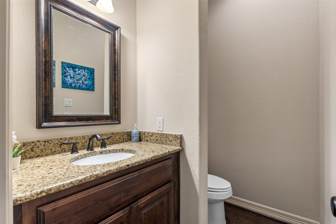 1916 Buffalo Speedway Leander, TX 78641 - Photo 8 of 30 a bathroom with a granite countertop sink and a toilet
