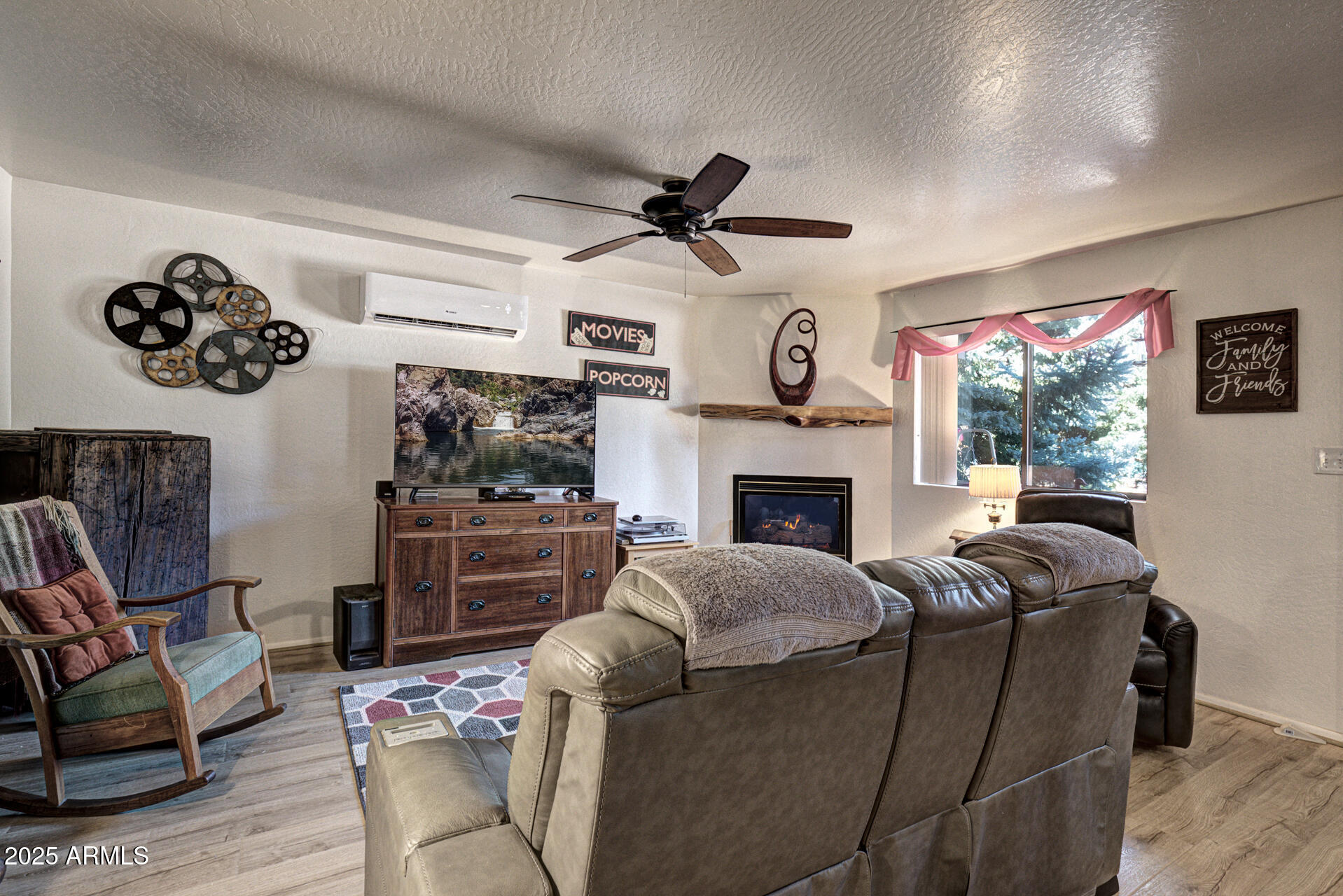 9019 Pinon Lane Pine, AZ 85544 - Photo 3 of 34 a living room with furniture a flat screen tv and a fireplace