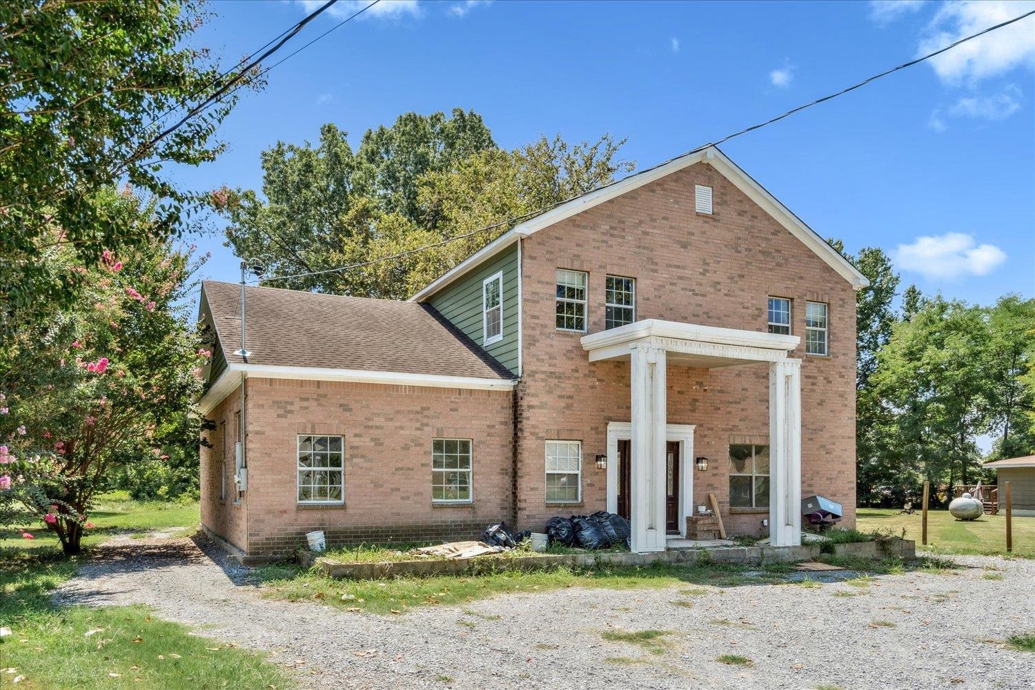 7723 Reese Road Memphis, TN 38133 - Photo 3 of 33 a view of a white house next to a yard with large trees