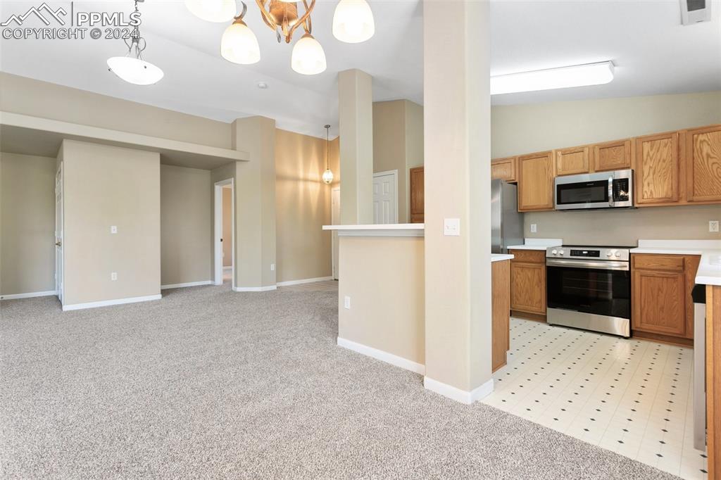 3831 Riviera Grove, Unit 204 Colorado Springs, CO 80922 - Photo 15 of 35 a view of kitchen with stainless steel appliances wooden floor and living room view