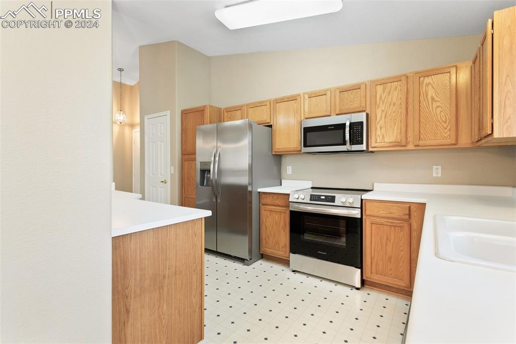 3831 Riviera Grove, Unit 204 Colorado Springs, CO 80922 - Photo 16 of 35 a kitchen with stainless steel appliances a stove a microwave and a refrigerator