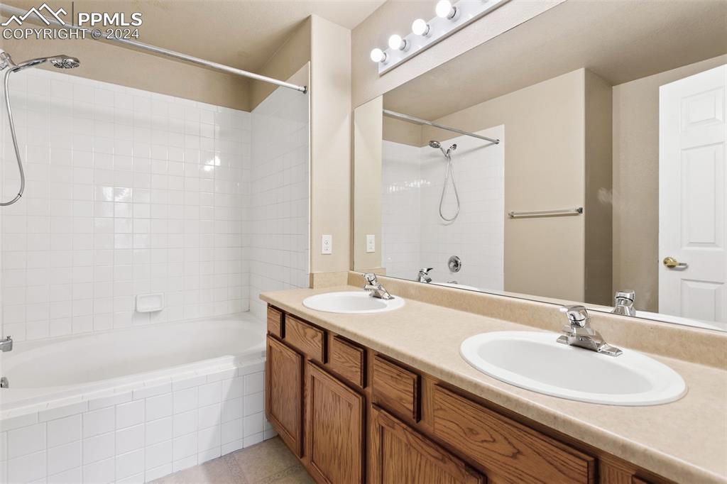 3831 Riviera Grove, Unit 204 Colorado Springs, CO 80922 - Photo 23 of 35 a bathroom with a sink double vanity granite tub shower and a mirror