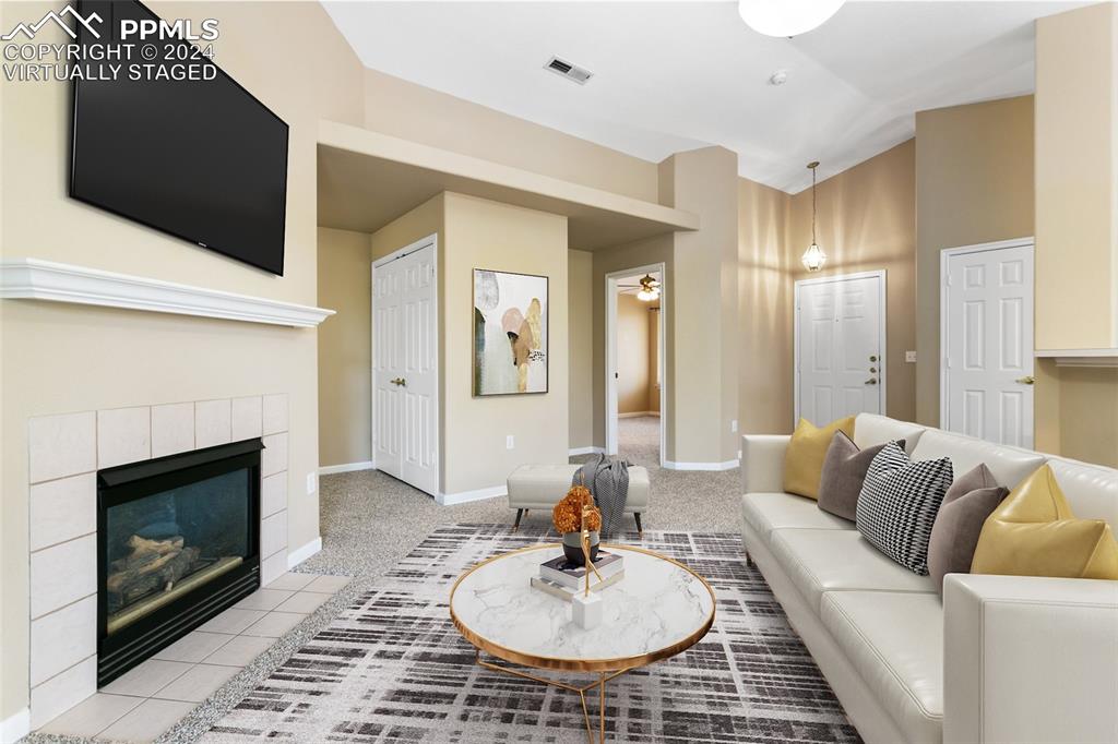 3831 Riviera Grove, Unit 204 Colorado Springs, CO 80922 - Photo 8 of 35 a living room with furniture a fireplace and a flat screen tv