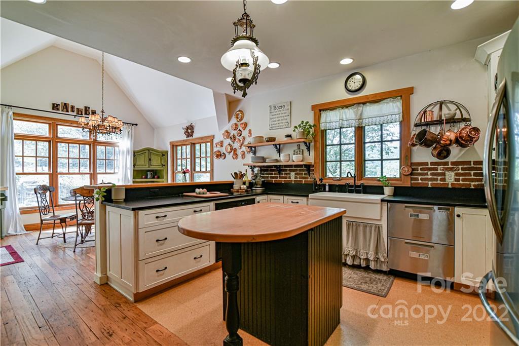 157 Poverty Branch Road Barnardsville, NC 28709 - Photo 11 of 48 a kitchen with stainless steel appliances granite countertop a stove a sink dishwasher and a dining table with wooden floor