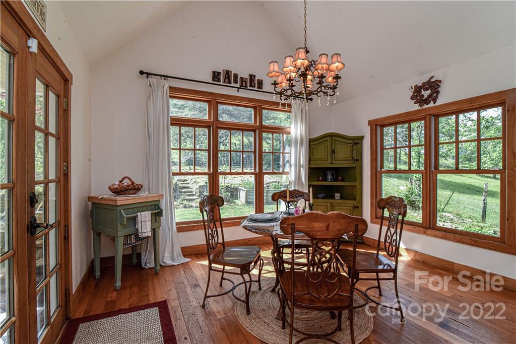 157 Poverty Branch Road Barnardsville, NC 28709 - Photo 14 of 48 a view of a dining room with furniture a chandelier and wooden floor
