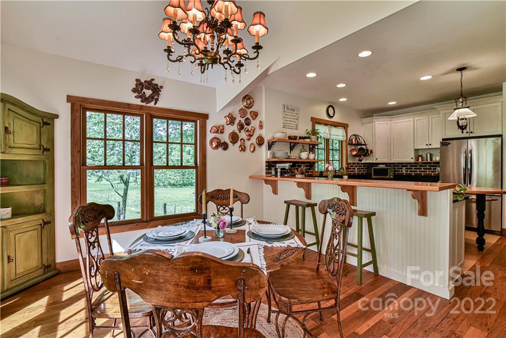 157 Poverty Branch Road Barnardsville, NC 28709 - Photo 15 of 48 a view of a dining room with furniture a chandelier and wooden floor