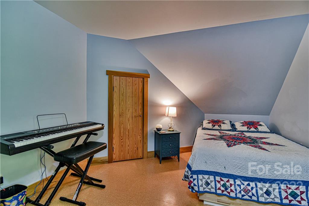 157 Poverty Branch Road Barnardsville, NC 28709 - Photo 30 of 48 a bedroom with furniture and a chandelier