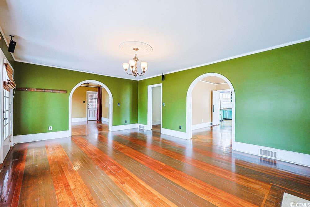 509 Beaty Street Conway, SC 29526 - Photo 4 of 40 Spare room with a chandelier, arched walkways, hardwood / wood-style flooring, and ornamental molding