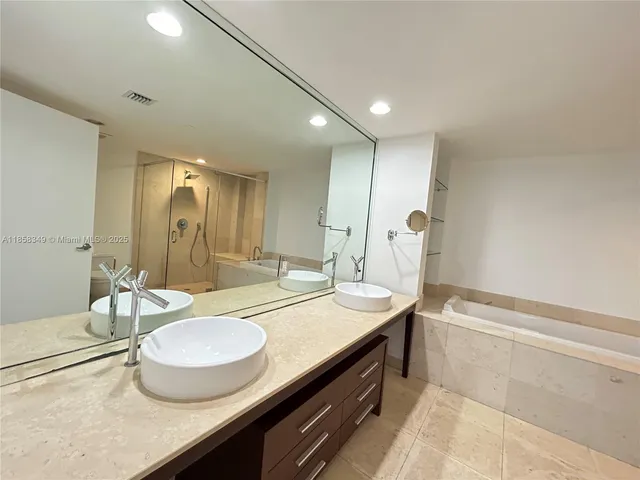 a bathroom with a granite countertop sink a toilet a mirror and bathtub