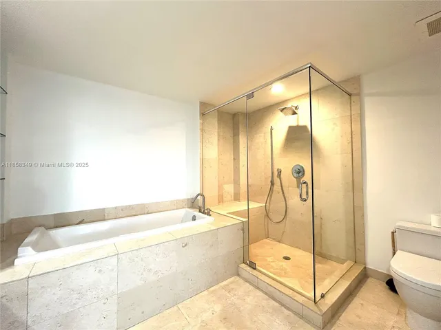a bathroom with a tub shower and toilet