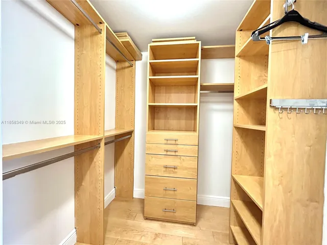 a view of walk in closet with empty racks