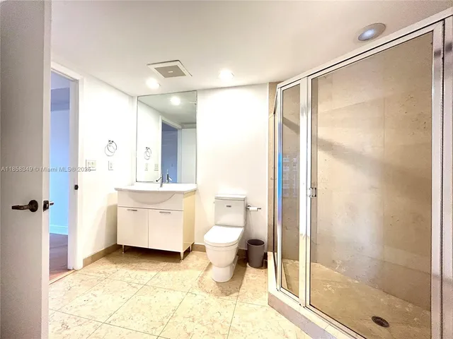 a bathroom with a granite countertop sink toilet and shower