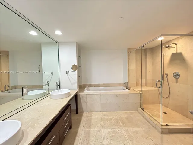 a spacious bathroom with a tub sink and mirror