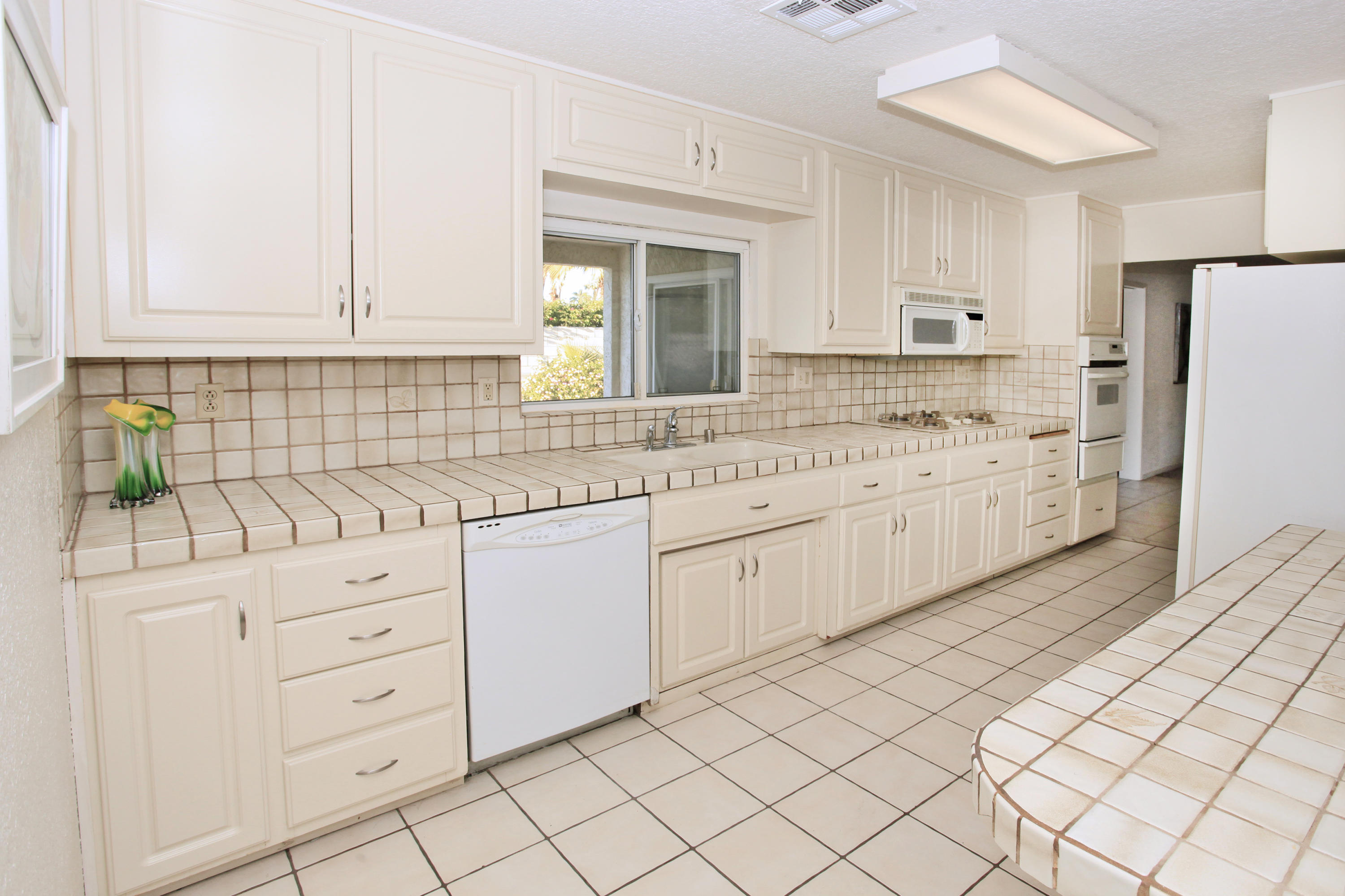 70090 Chappel Road Rancho Mirage, CA 92270 - Photo 14 of 26 a kitchen with granite countertop white cabinets and white appliances