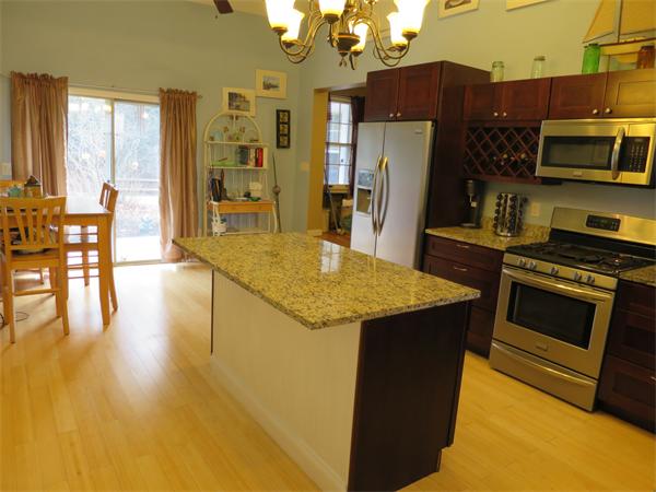 3096 Boston Road Wilbraham, MA 01095 - Photo 3 of 18 a kitchen with stainless steel appliances granite countertop a stove top oven a sink dishwasher a dining table and chairs with wooden floor