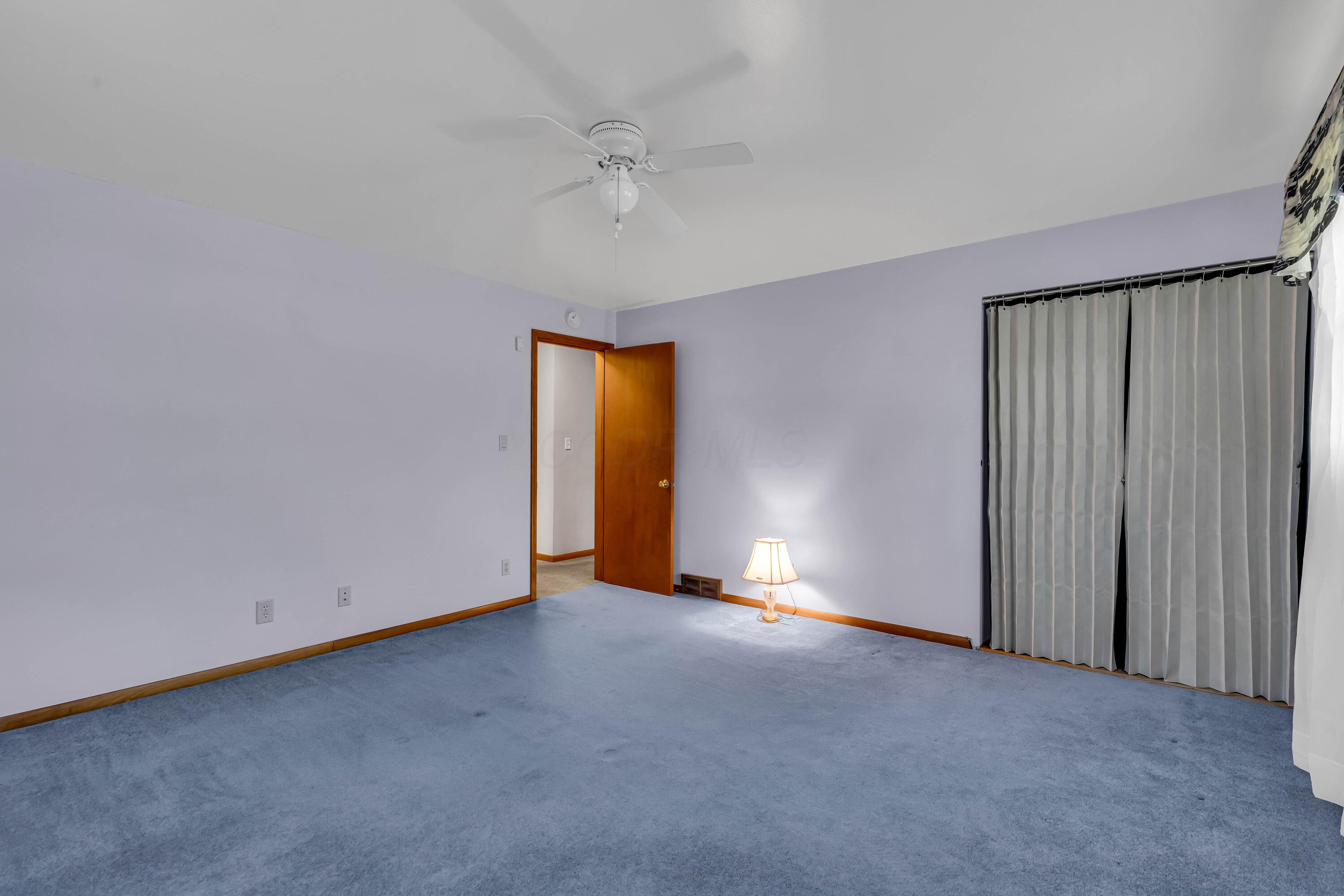1213 East Cooke Road Columbus, OH 43224 - Photo 31 of 57 • Blue carpet • Hardwood flooring under carpet • Blue painted walls • Lighted ceiling fan • Lighted closet