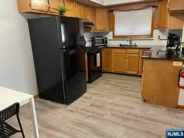 a kitchen with stainless steel appliances granite countertop a refrigerator and a sink