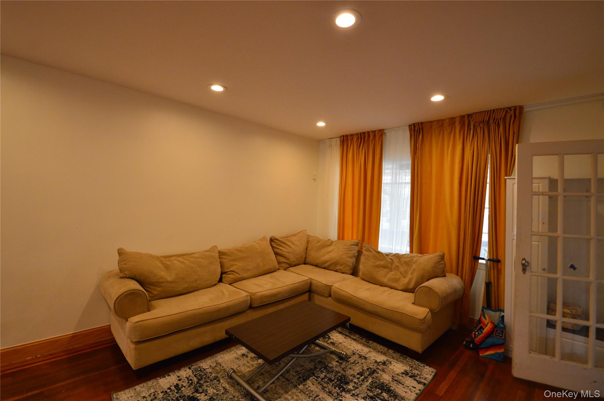 105-46 65th Road Queens, NY 11375 - Photo 12 of 20 a living room with furniture and a window