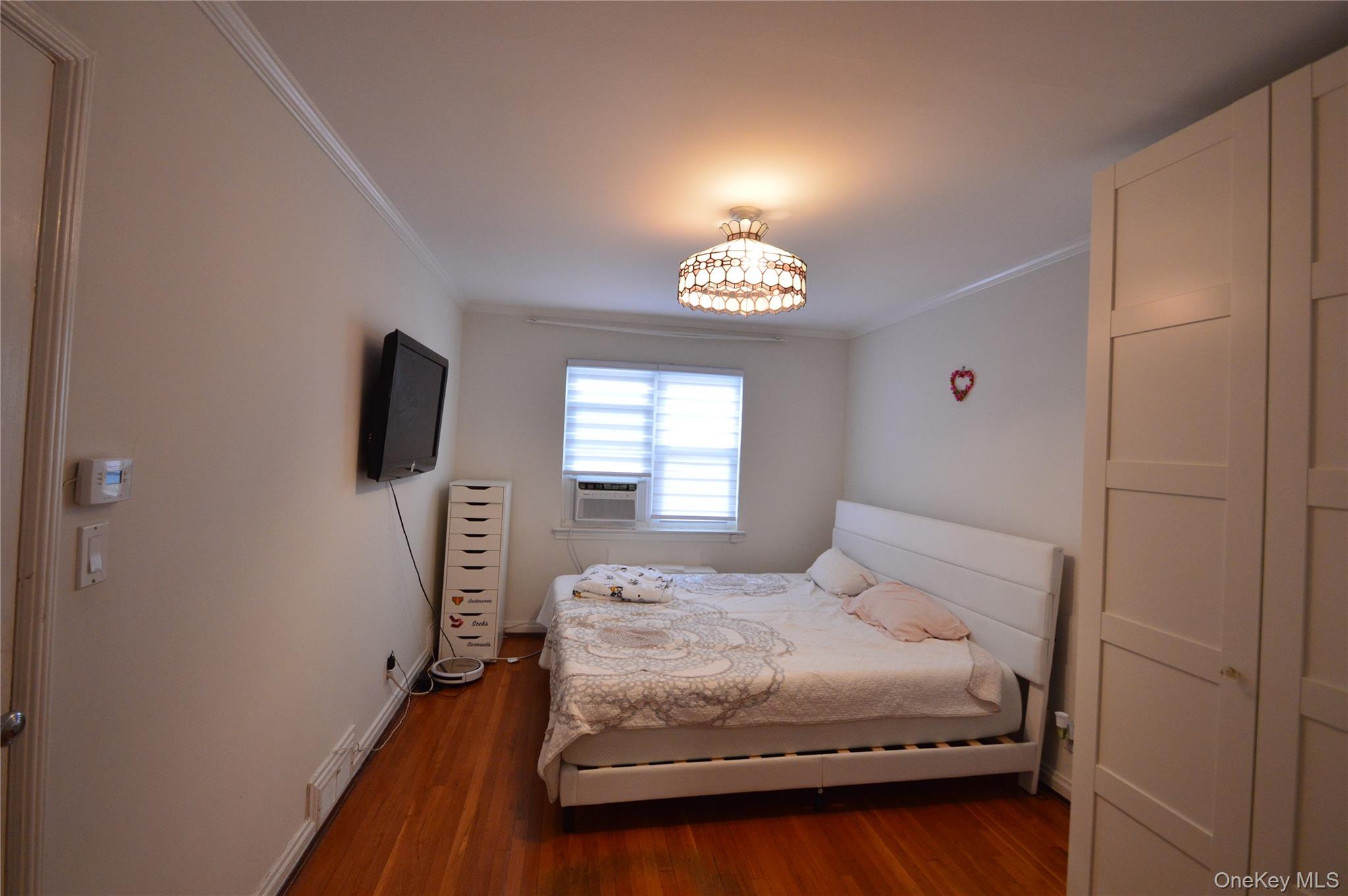 105-46 65th Road Queens, NY 11375 - Photo 16 of 20 a bedroom with a bed and a window