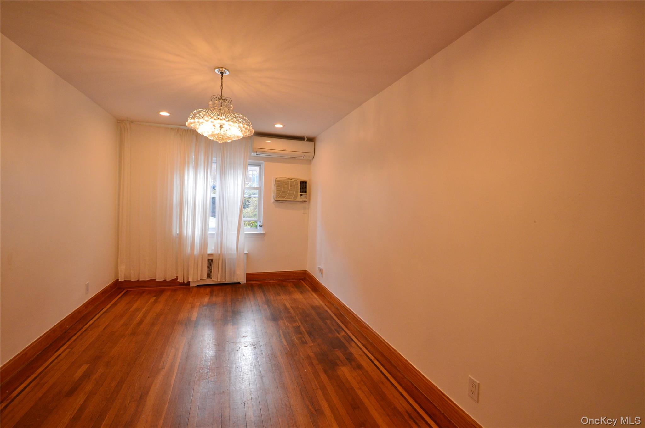 105-46 65th Road Queens, NY 11375 - Photo 20 of 20 a view of an empty room with wooden floor and a window