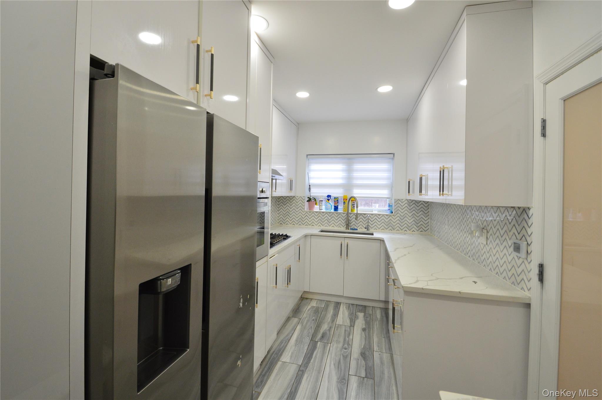 105-46 65th Road Queens, NY 11375 - Photo 2 of 20 a kitchen with a refrigerator sink and cabinets