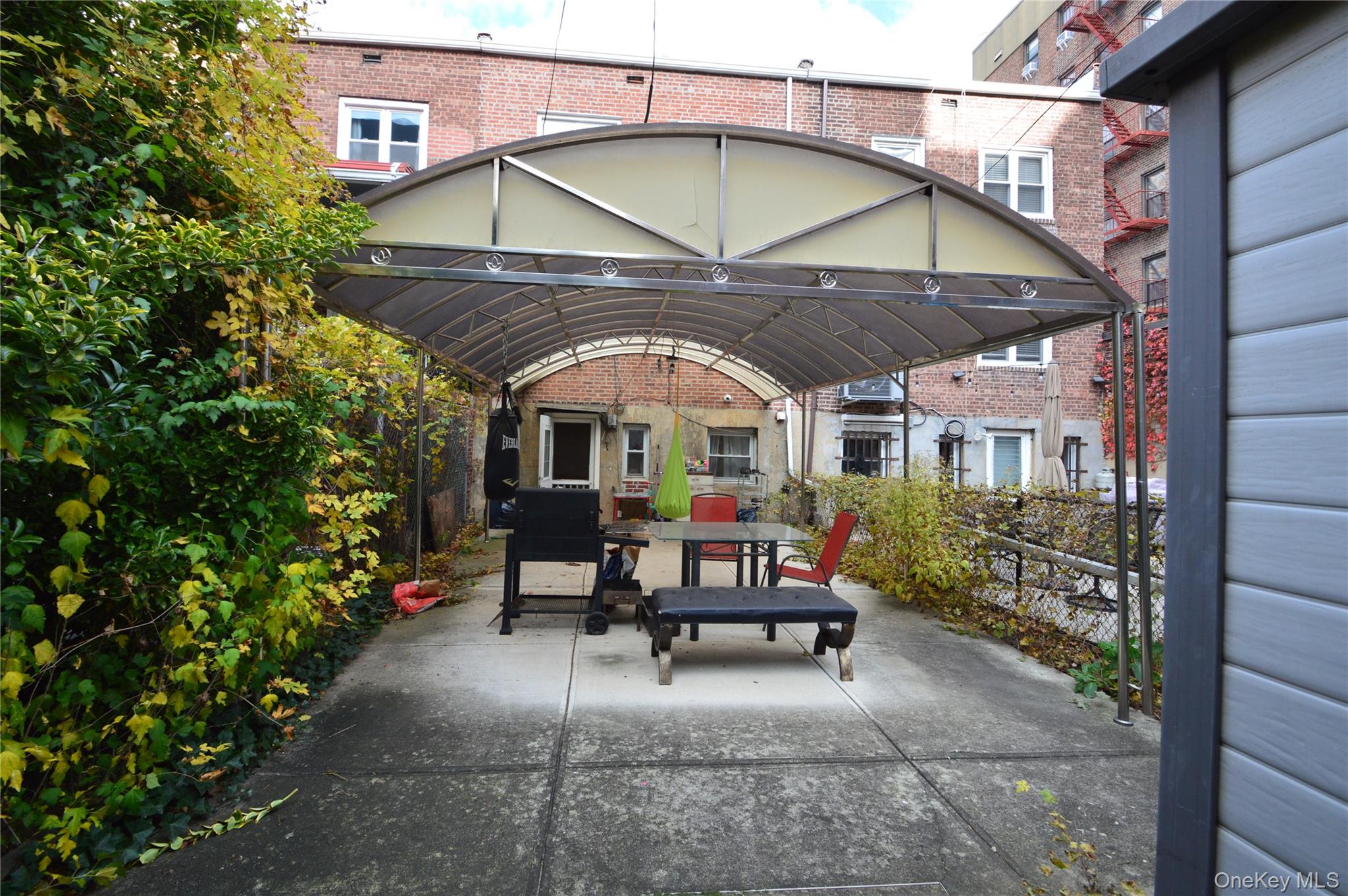 105-46 65th Road Queens, NY 11375 - Photo 7 of 20 a view of a chairs and table in the patio next to a yard