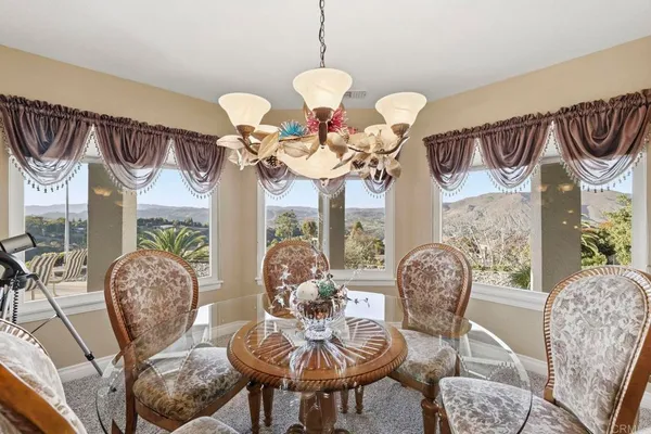 a view of a dining room with furniture and chandelier
