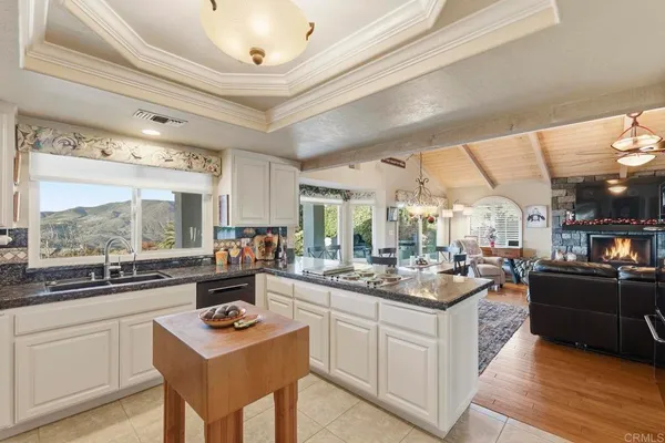 a kitchen with stainless steel appliances a stove a sink dishwasher and white cabinets with wooden floor
