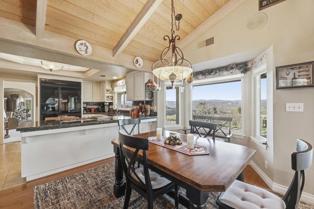 1524 Zutano Lane Fallbrook, CA 92028 - Photo 17 of 49 a view of a dining room with furniture a chandelier and large windows