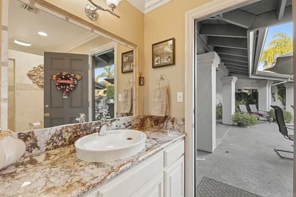 a en suite bathroom with a granite countertop sink and a mirror