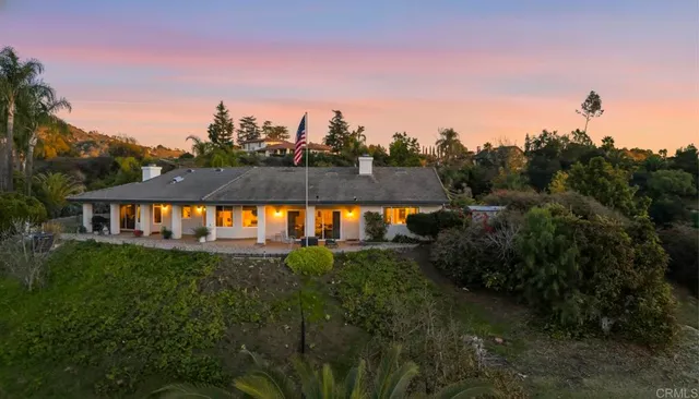 a view of a house with backyard and sitting area