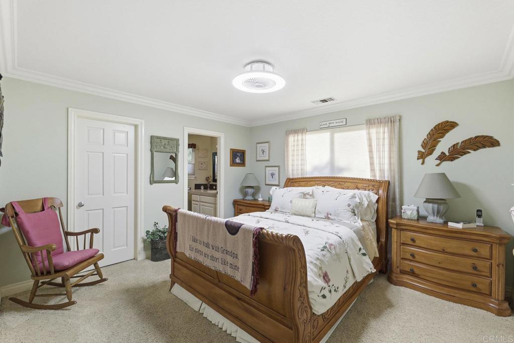 1524 Zutano Lane Fallbrook, CA 92028 - Photo 31 of 49 a bedroom with a bed and a chandelier