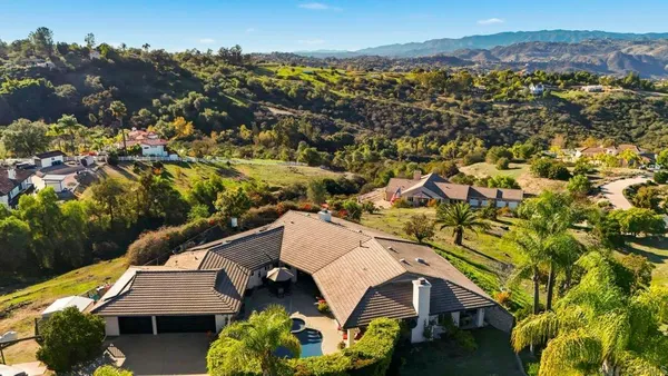 an aerial view of a house with a yard and lake view