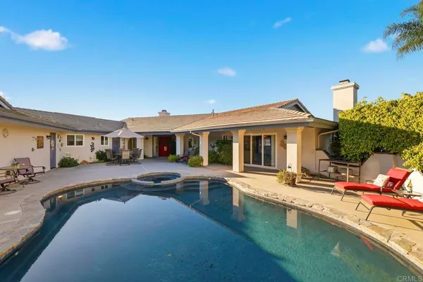 a front view of a house with swimming pool having outdoor seating