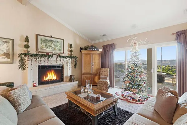 a living room with furniture a fireplace and a large window