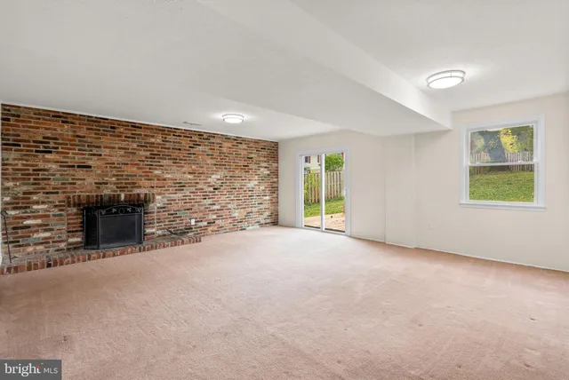 a view of an empty room with a fireplace and a window