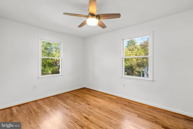 a view of empty room with window and wooden floor