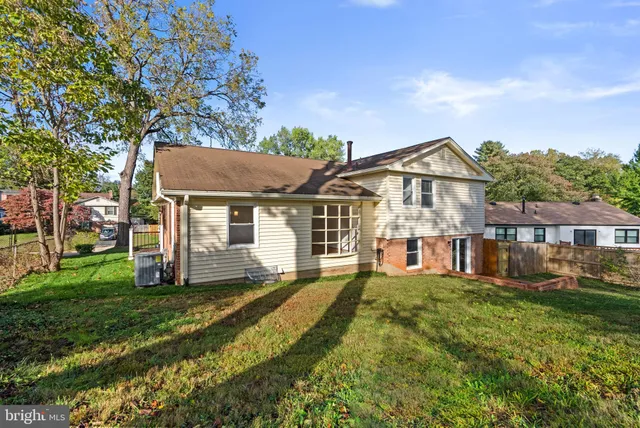 a view of a house with a big yard and large tree