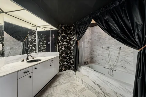 a bathroom with a granite countertop sink mirror and cabinets
