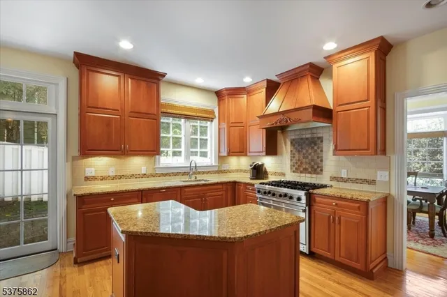 a kitchen with stainless steel appliances granite countertop a stove a sink and a microwave