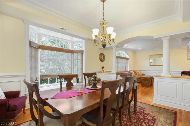 a view of a dining room with furniture a chandelier and wooden floor