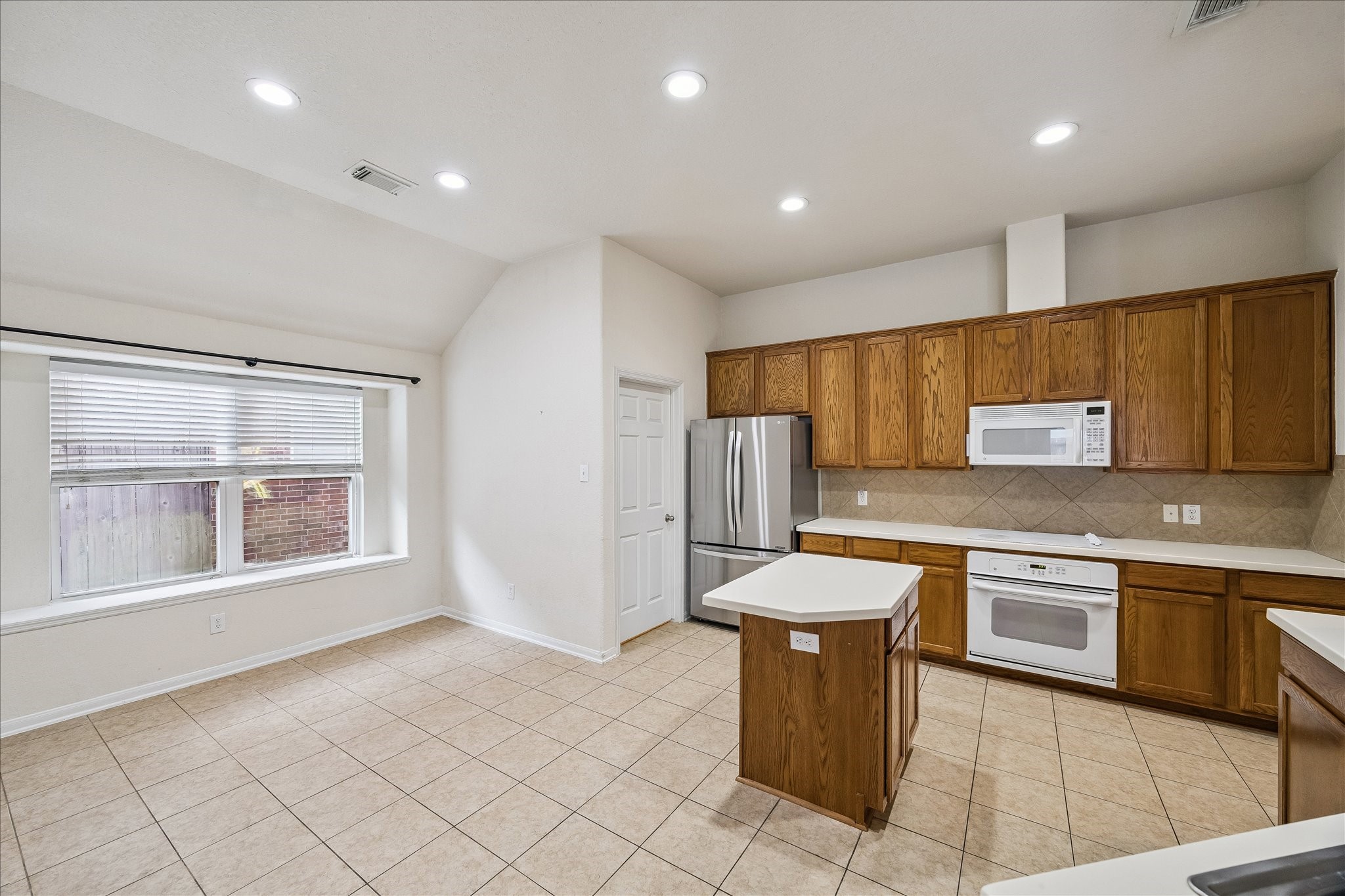 19403 Valiant Woods Drive Spring, TX 77379 - Photo 12 of 42 a kitchen with stainless steel appliances granite countertop a sink and a stove top oven with wooden floor