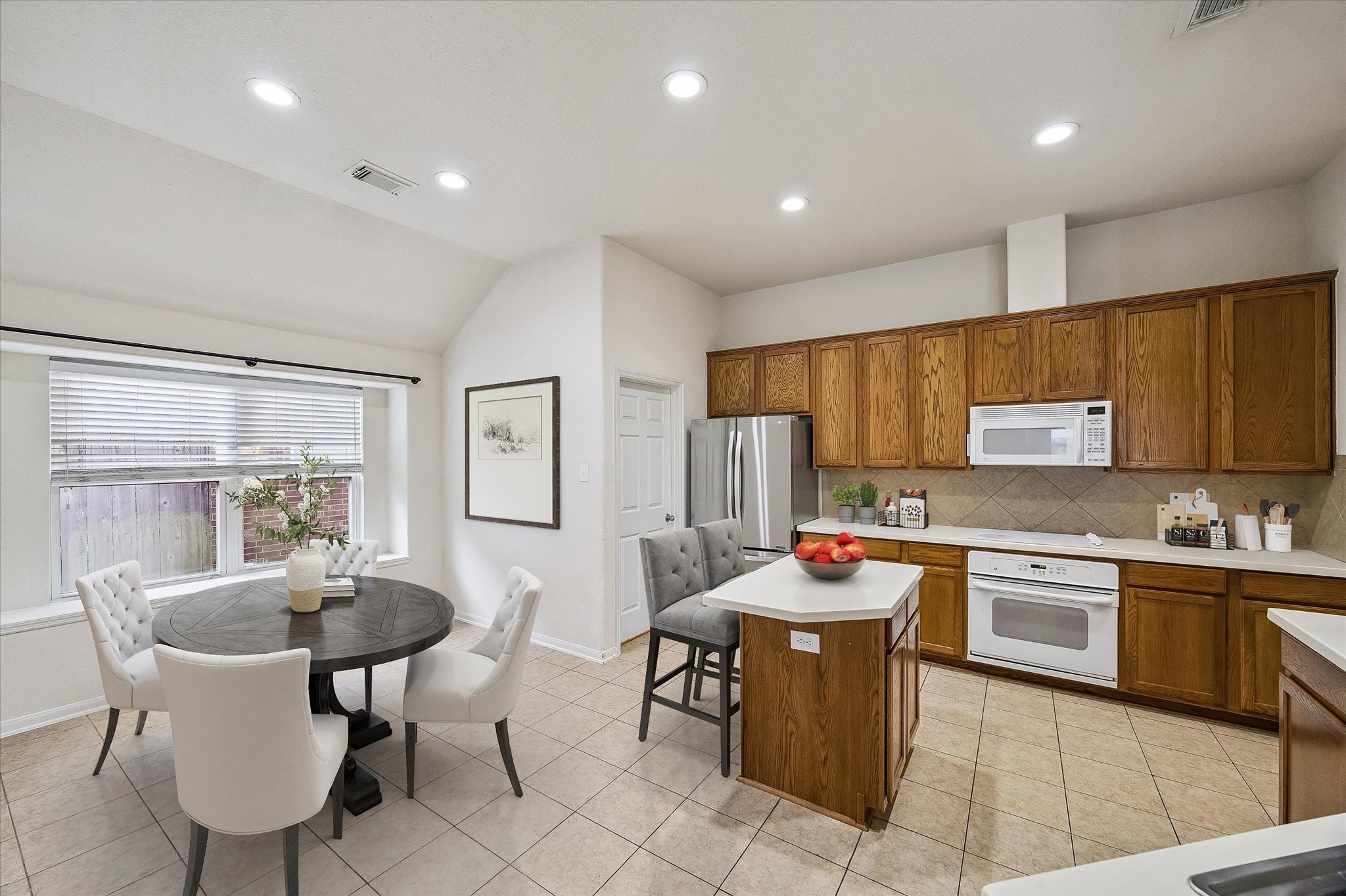 19403 Valiant Woods Drive Spring, TX 77379 - Photo 13 of 42 a dining room with stainless steel appliances kitchen island granite countertop a table and chairs in it