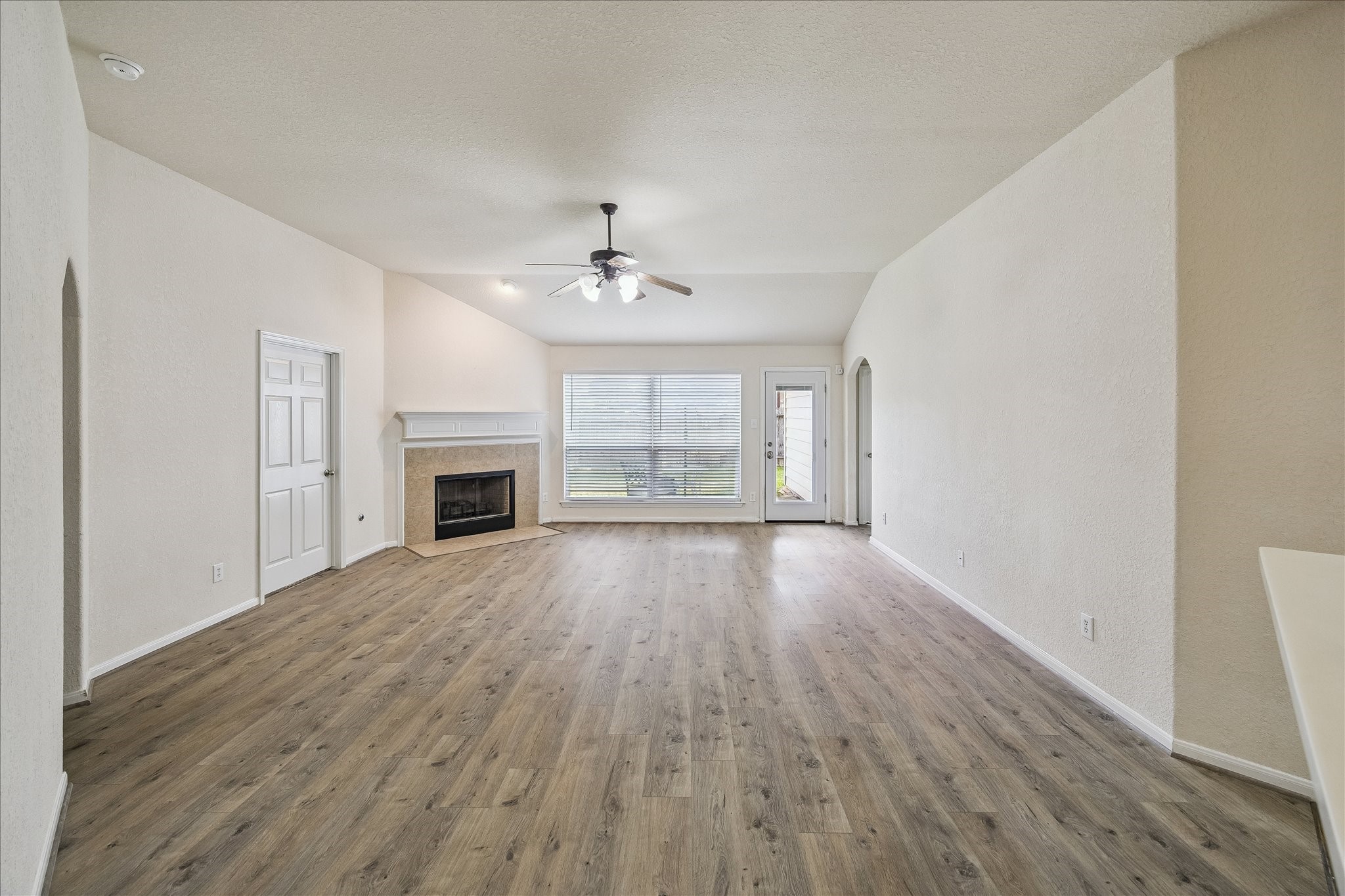 19403 Valiant Woods Drive Spring, TX 77379 - Photo 19 of 42 an empty room with wooden floor fireplace and windows