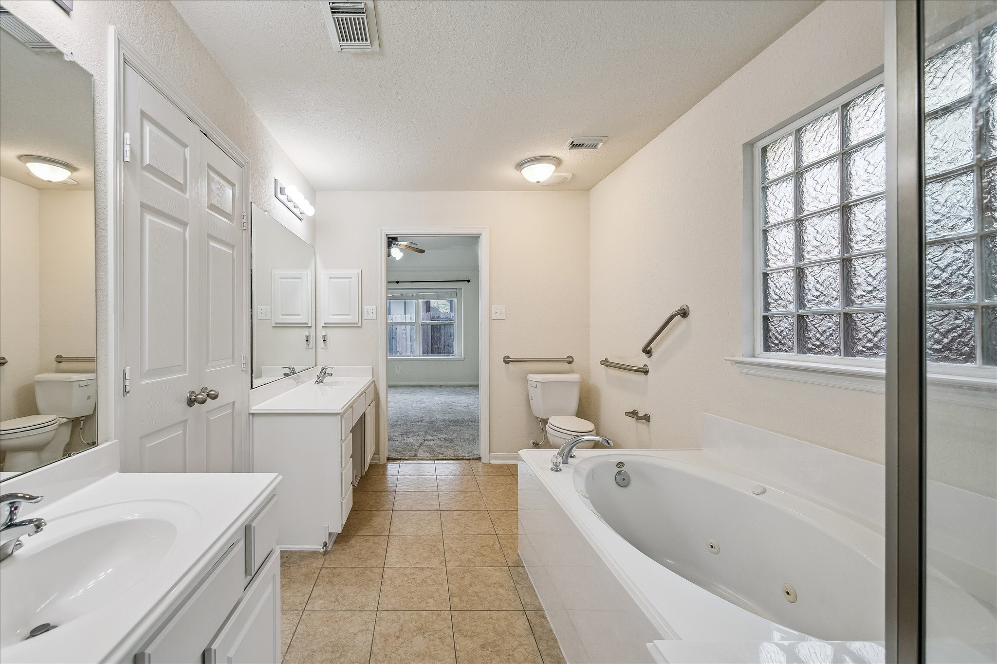 19403 Valiant Woods Drive Spring, TX 77379 - Photo 29 of 42 a bathroom with a granite countertop tub a sink and a large mirror