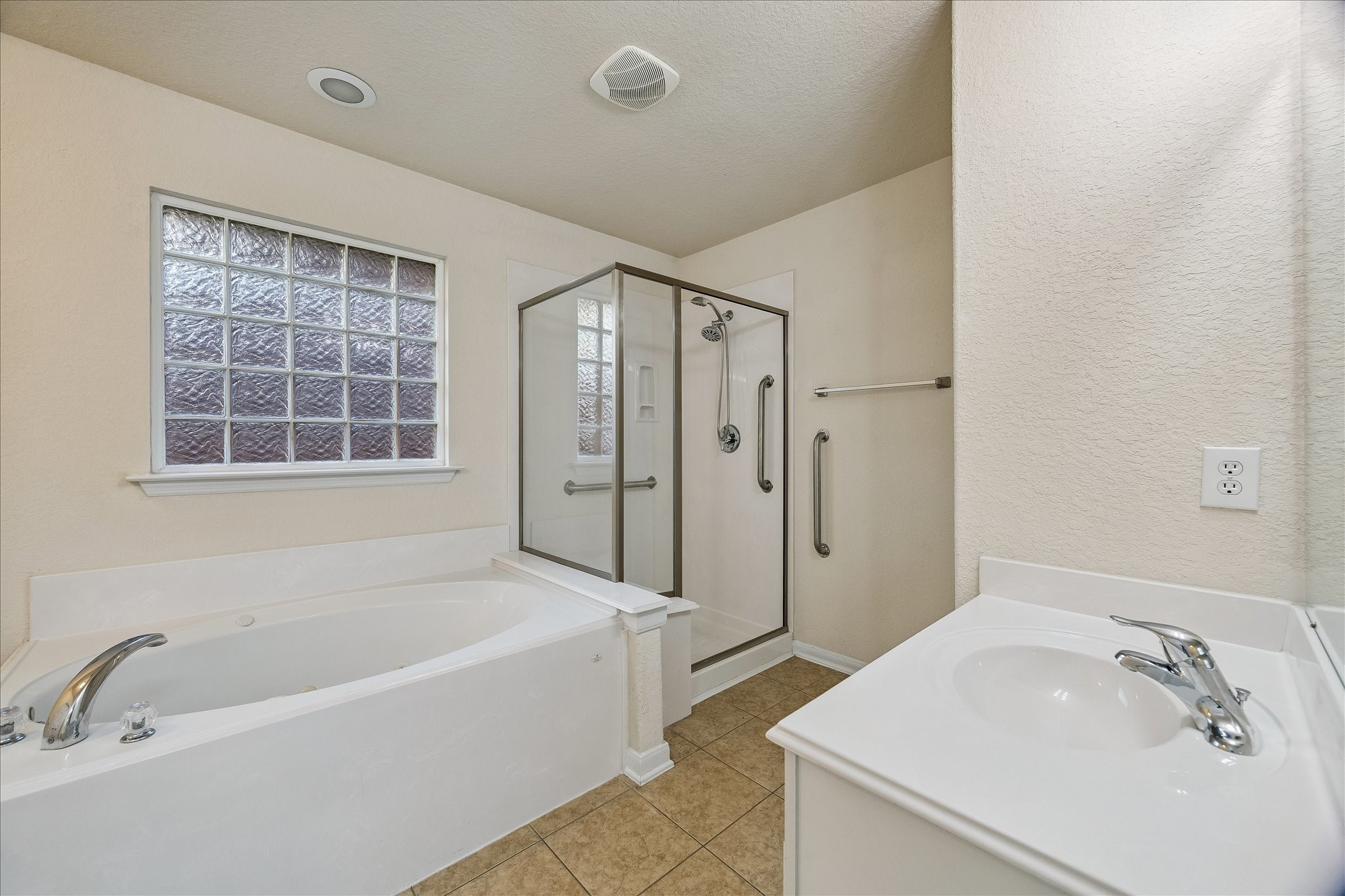 19403 Valiant Woods Drive Spring, TX 77379 - Photo 30 of 42 a bathroom with a tub sink shower and a mirror
